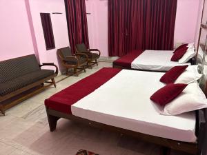 a hotel room with two beds and a couch at Hotel Padamaa Palace in Varanasi +13 photos