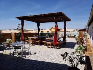 a patio with a table and chairs and a pavilion at Hospedagem Terral Beach Canoa Quebrada in Aracati