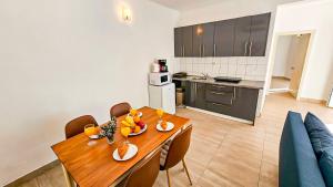 a kitchen and dining room with a wooden table and chairs at Beach front with Swimming pool, Illyria Resort Apt 101 in Milna