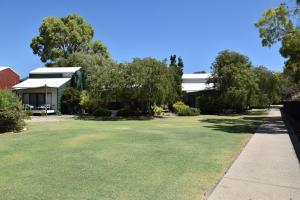 a building with a green lawn in front of it at Sea Renity Preston Beach in Preston Beach