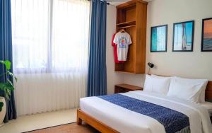 a bedroom with a bed and a shirt hanging in a window at Lay Day Hostel Uluwatu in Uluwatu +22 photos