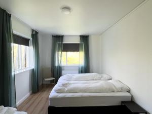 a bedroom with two beds and a window at Eiðar - Apartments in Eiðar