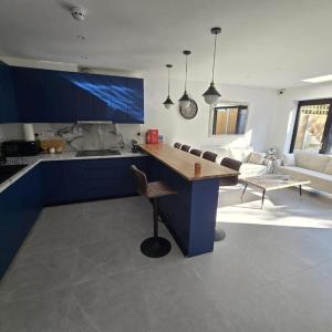 a kitchen with a blue island in a living room at Albion's House in Luton