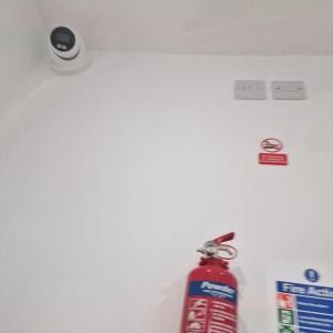 a fire hydrant with a red fire extinguisher on a wall at Albion's House in Luton