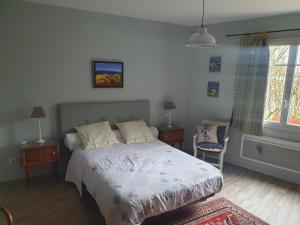 a bedroom with a bed and two tables and a window at Chambre d'hôtes Le Luquet in Chazelles