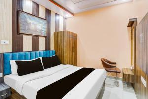 a bedroom with a large bed and a chair at Hotel O Rameshwar Inn in Prayagraj