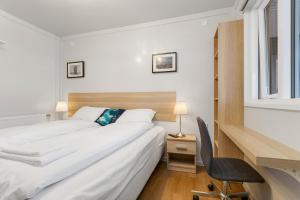 ein Schlafzimmer mit einem Bett, einem Schreibtisch und einem Stuhl in der Unterkunft Hotel Boli Keflavik in Njarðvík