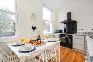 a kitchen with a white table with a bowl of fruit at Minster's Keep- Near York Minster & Free Parking in York