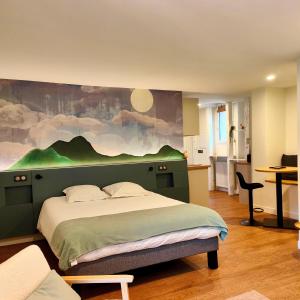 a bedroom with a bed with a painting on the wall at Les appart'hotels de la fontaine in Autoire