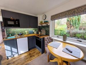 a kitchen with a table and a table and a window at The Pack Horse Exmoor National Park Allerford Riverside Cottage & Apartments in Minehead