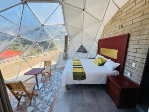 a room with a bed and a large window at Glamping Mascota in La Providencia