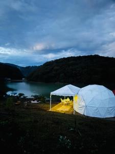 a tent with a table and chairs next to a lake at Glamping Mascota in La Providencia