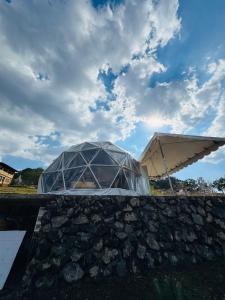 a glass dome on top of a stone wall with an umbrella at Glamping Mascota in La Providencia +7 photos