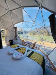 a bedroom in a dome tent with a bed and chairs at Glamping Mascota in La Providencia
