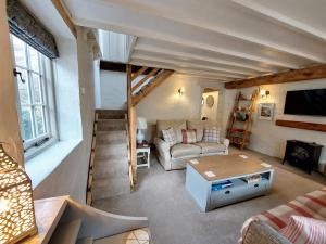 a living room with a couch and a table at The Pack Horse Exmoor National Park Allerford Riverside Cottage & Apartments in Minehead