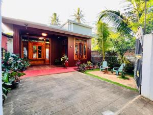 a house with a porch and a driveway at Coral Bay Villa in Pottuvil