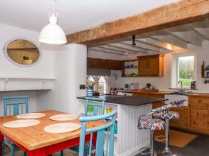 a kitchen with a wooden table and chairs at Old Sunday School in Bideford