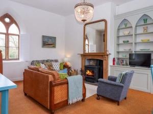 a living room with a couch and a mirror at Old Sunday School in Bideford