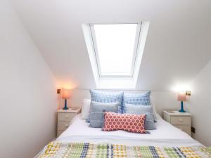 a bedroom with a bed with pillows and a window at Old Sunday School in Bideford