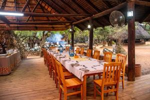 a long table on a deck with wooden chairs at Mlilwane Game Sanctuary in Lobamba