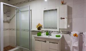 a white bathroom with a sink and a shower at Belle Vacance in Grand Anse +27 photos