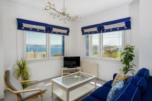 a living room with a blue couch and a tv at The Marina View in Lavrio