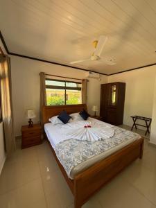 a bedroom with a large bed with white sheets at Belle Vacance in Grand Anse