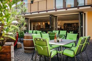 un restaurante con sillas y mesas verdes y un bar en Weingut Mussel, en Wörrstadt 3 fotos más