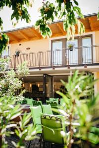 un patio con sillas verdes frente a un edificio en Weingut Mussel, en Wörrstadt