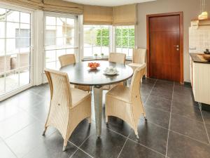 uma cozinha e sala de jantar com mesa e cadeiras em Villa with pool sauna and bubble bath em Borgloon