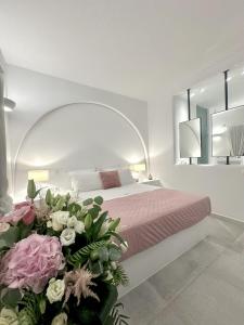 a bedroom with a bed with pink and white flowers at Alexander Suites in Drios