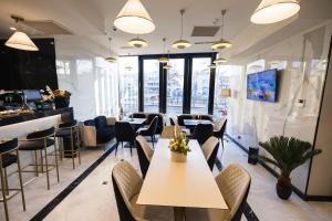 a restaurant with tables and chairs and a bar at Le Blanc Cotroceni Hotel in Bucharest