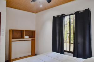 a bedroom with a bed and a window at Casa escondida in Uvita