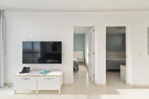 a white room with a bed and a table at Mariposa del Sol in Patalavaca