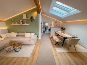 a living room with a couch and a table at Scandinavian Alpine Lodge nahe Tegernsee - stilvoll & ruhig in Reichersbeuern