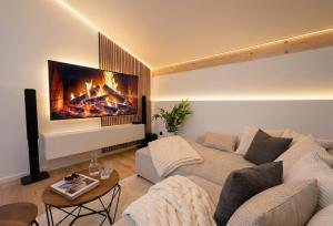 a living room with a couch and a fireplace at Scandinavian Alpine Lodge nahe Tegernsee - stilvoll & ruhig in Reichersbeuern