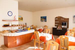 a restaurant with a table and chairs and a kitchen at Hotel Europa Pforzheim in Pforzheim
