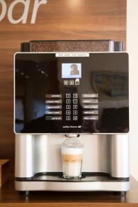 a coffee maker with a glass of coffee at Hotel Europa Pforzheim in Pforzheim