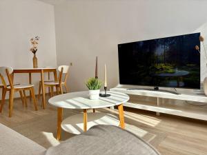 a living room with a large tv and a table at Przy Zamenhofa in Nowa Sól