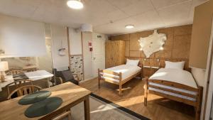 a small room with two beds and a table at Lumi Guest House in Arvidsjaur