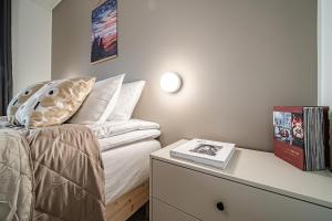 a bedroom with a bed and a table with a book at Gielas Joiku Chalet - Ski-in Ski-out - Mountain View - incl 2 ski passes in Kittilä