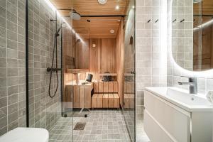 a bathroom with a shower and a toilet and a sink at Gielas Joiku Chalet - Ski-in Ski-out - Mountain View - incl 2 ski passes in Kittilä