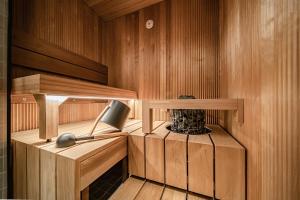 a sauna with a lamp in a wooden room at Gielas Joiku Chalet - Ski-in Ski-out - Mountain View - incl 2 ski passes in Kittilä +29 photos