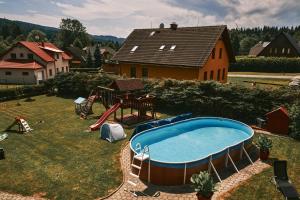a backyard with a swimming pool in the grass at Penzion pod Šerákem - celý objekt Ostružná - Jeseníky in Ostružná