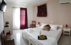 a bedroom with a bed with a tray of fruit on it at Maistrali Studios Skiathos in Koukounaries