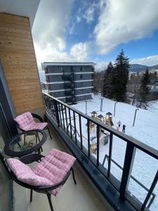 a balcony with two chairs and a view of a ski slope at studio in Itʼkhvisi