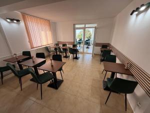a restaurant with tables and chairs in a room at Pensiunea Margareta in Baile Felix