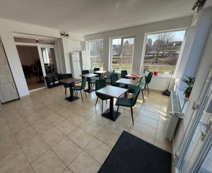 a dining room with tables and chairs and windows at Pensiunea Margareta in Baile Felix