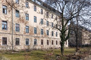 a large building with a tree in front of it at NUMBR25 - self service & low budget Hotel in Graz