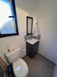 a bathroom with a white toilet and a sink at Casa Cajita in Rancul +24 photos